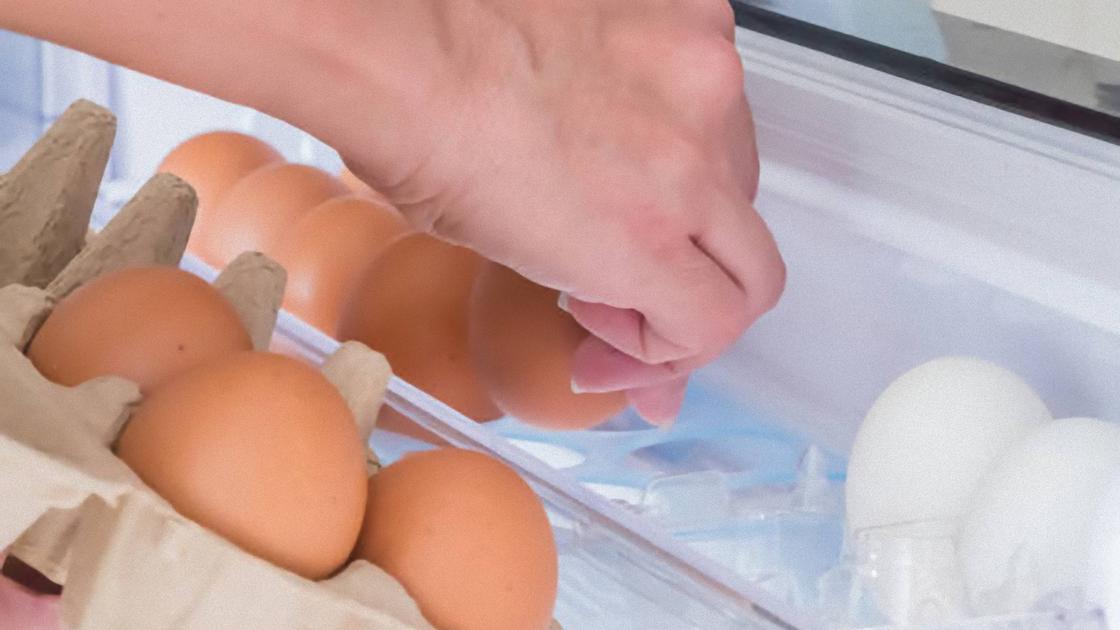 Яйца перекладывают из лотка в емксоть для яиц в холодильнике