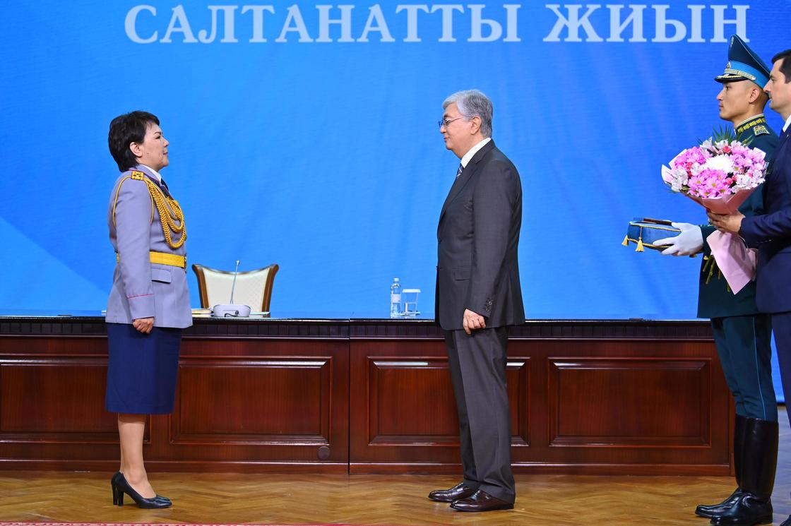 Президент Казахстана Касым-Жомарт Токаев вручает награду полицейскому