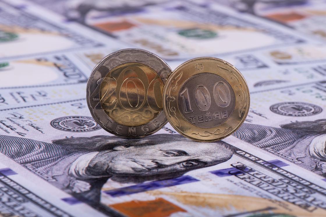 Монеты тенге стоят ребром на долларах