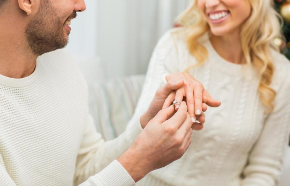 Мужчина надевает женщине на палец обручальное кольцо