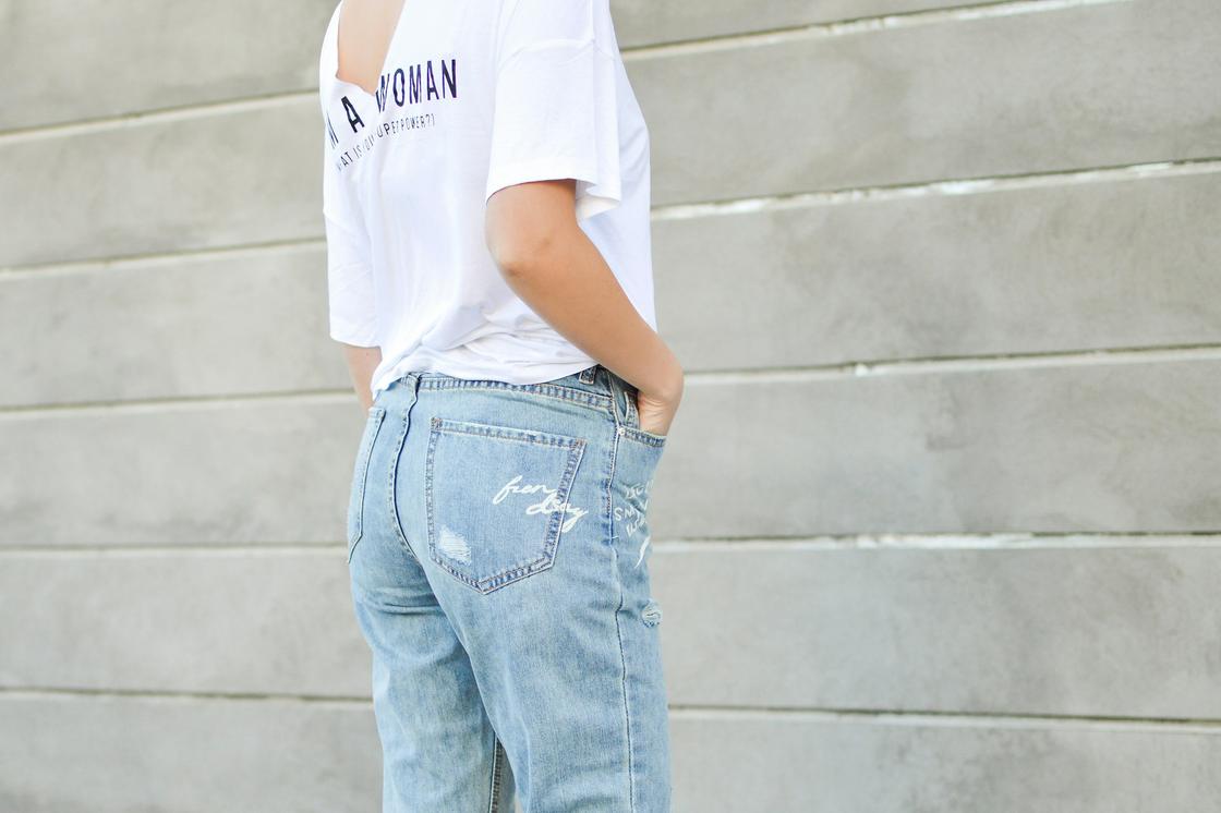 Осветленные джинсы и надпись, выполненная белым цветом