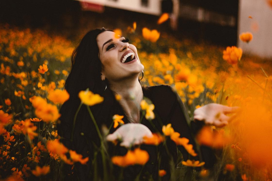 Девушка смеется на аллее цветов