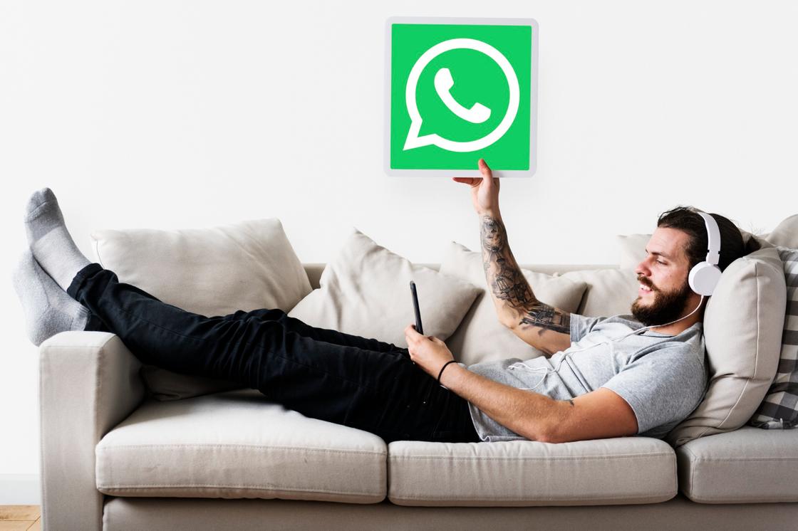 Человек на диване с логотипом WhatsApp