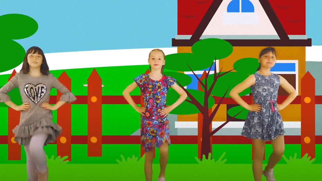 Три девочки в платьях танцуют на фоне аппликации с домиком и деревьями