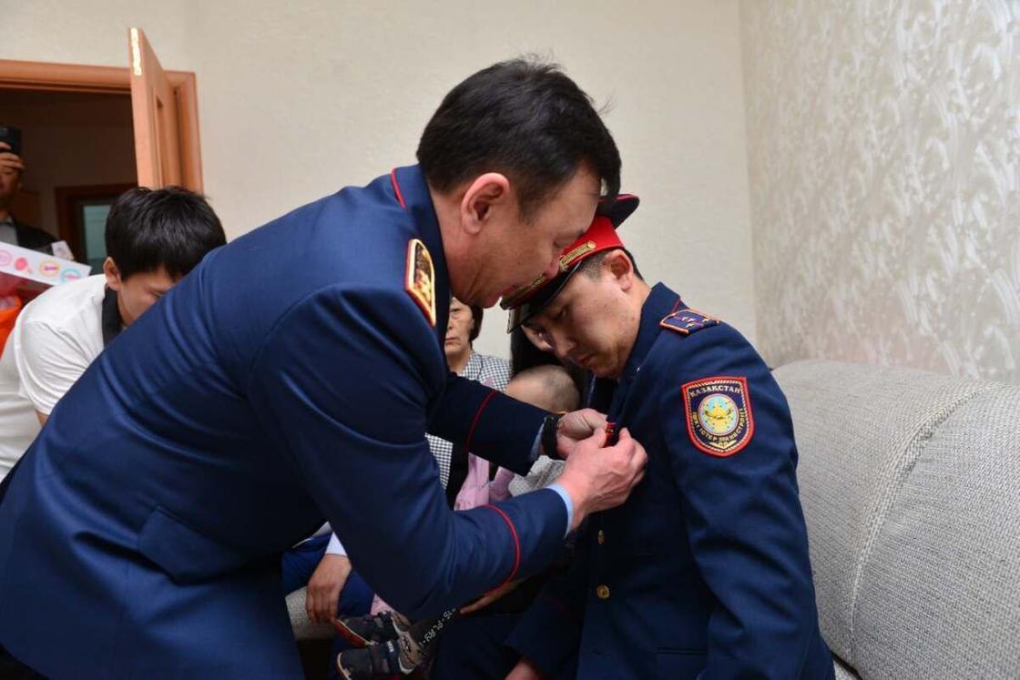 Марат Кожаев награждает полицейского