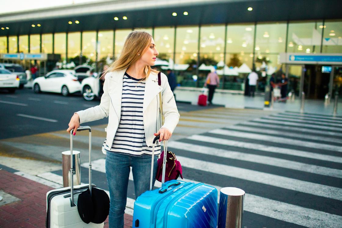 Девушка с чемоданами в аэропорту