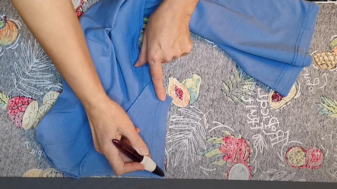 Рукав футболки обводят маркером на изнаночной стороне цветной ткани