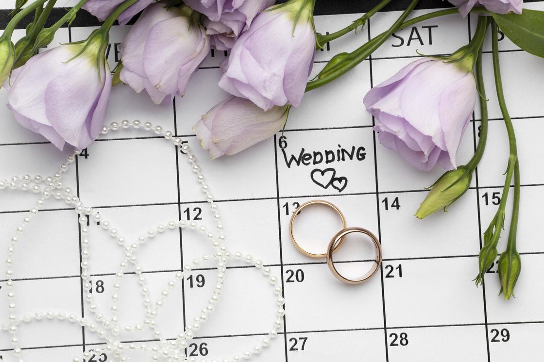 Календарь, обручальные кольца, цветы и бусы