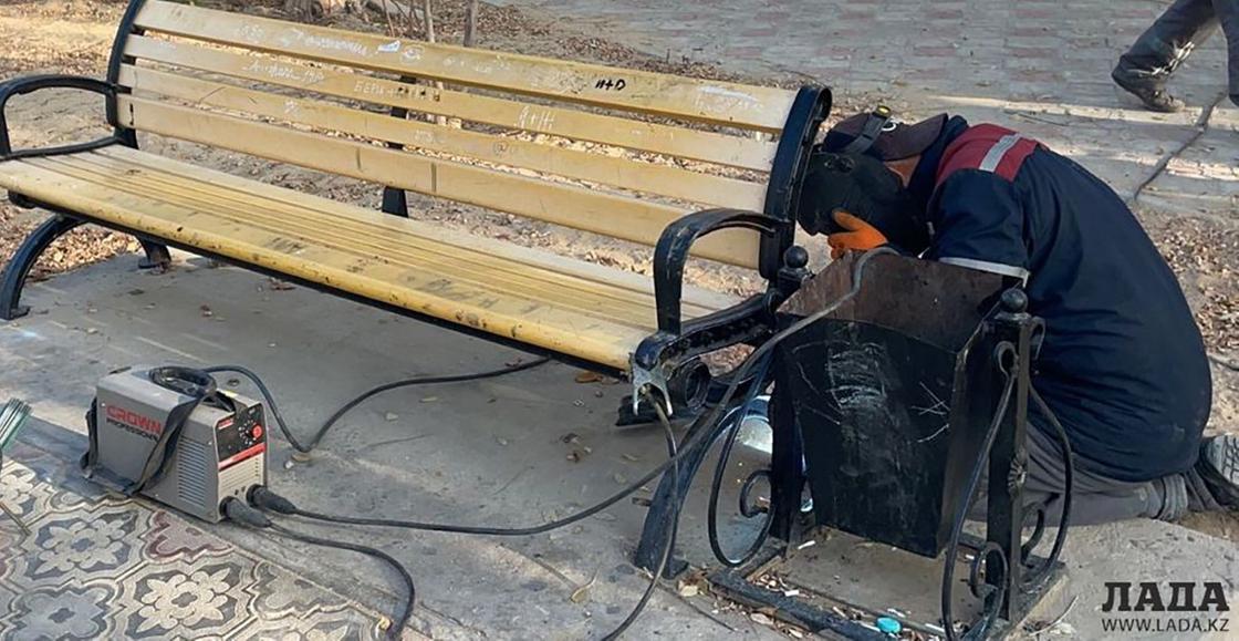 Рабочий ремонтирует скамейку в Актау