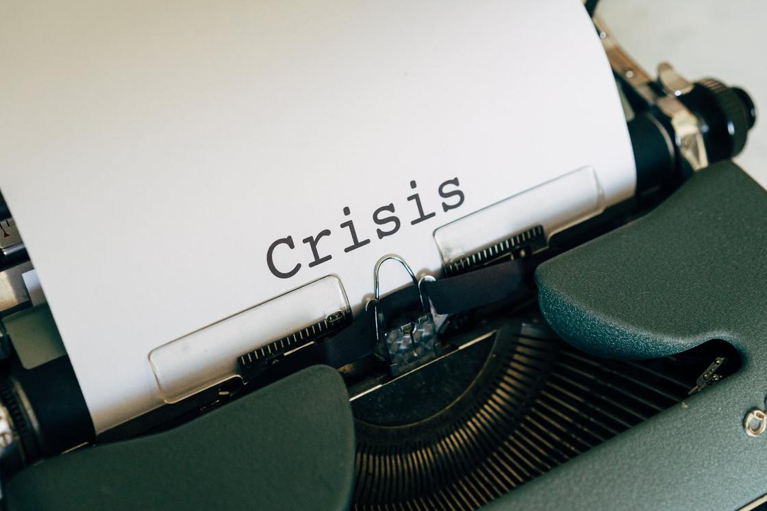 Белый лист со словом "кризис" на английском языке, вставленный в печатную машинку