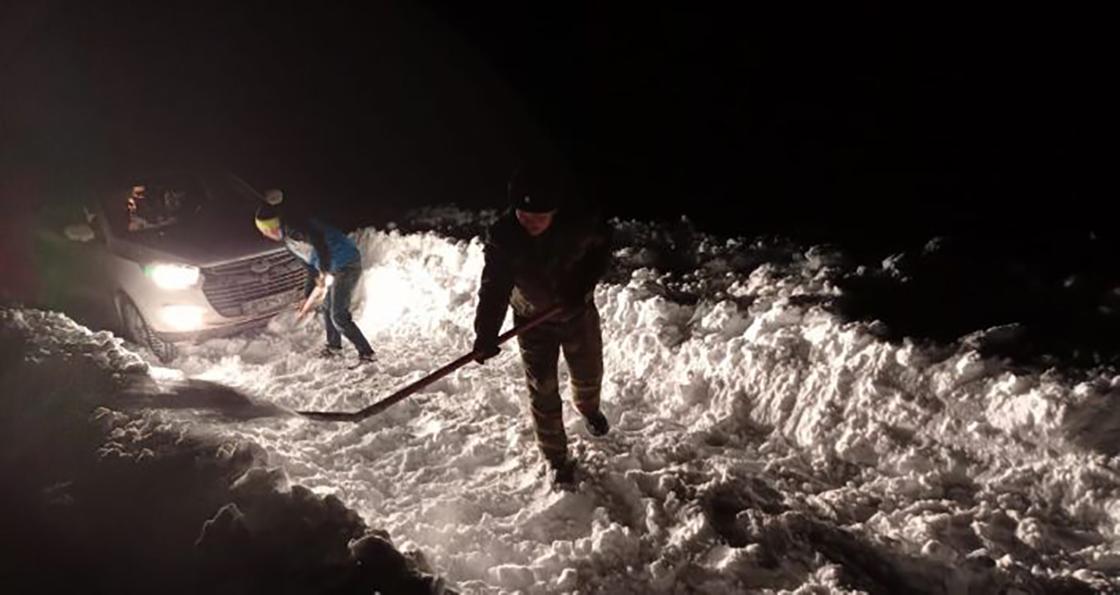 Люди с лопатами расчищают дорогу от снега