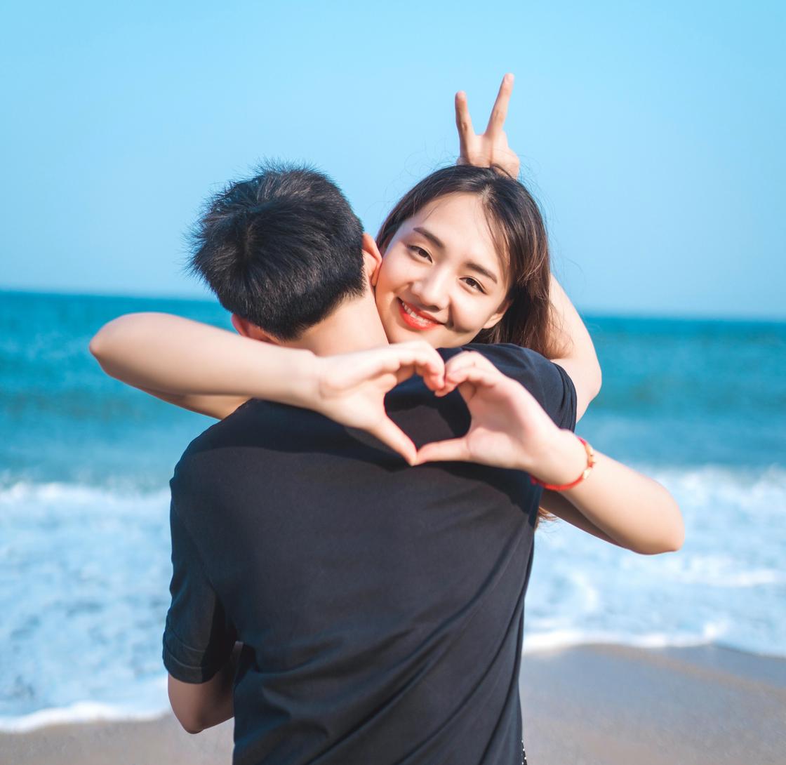 Девушка и парень обнимаются на фоне моря