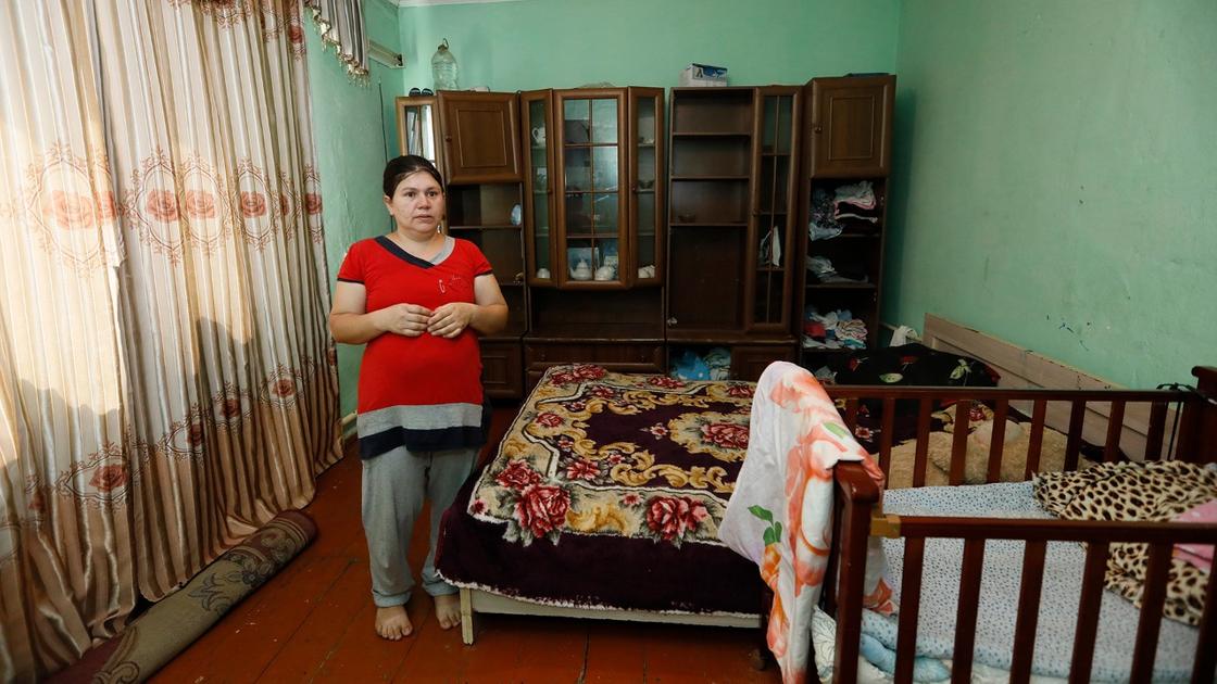 Женщина стоит в комнате с двумя кроватями