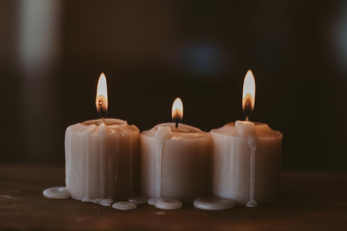 Три свечи вплотную стоят на столе и горят