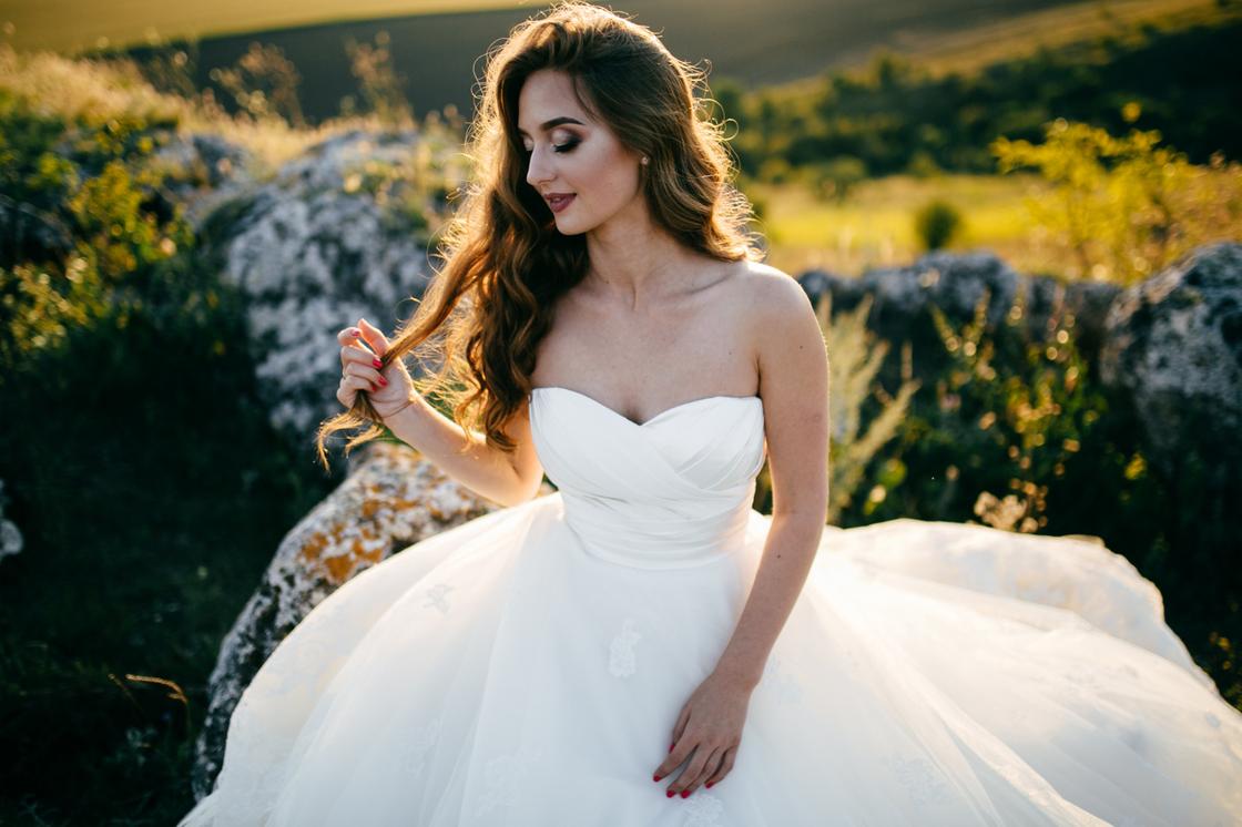 Красивая девушка в свадебном платье-бюстье с пышной юбкой