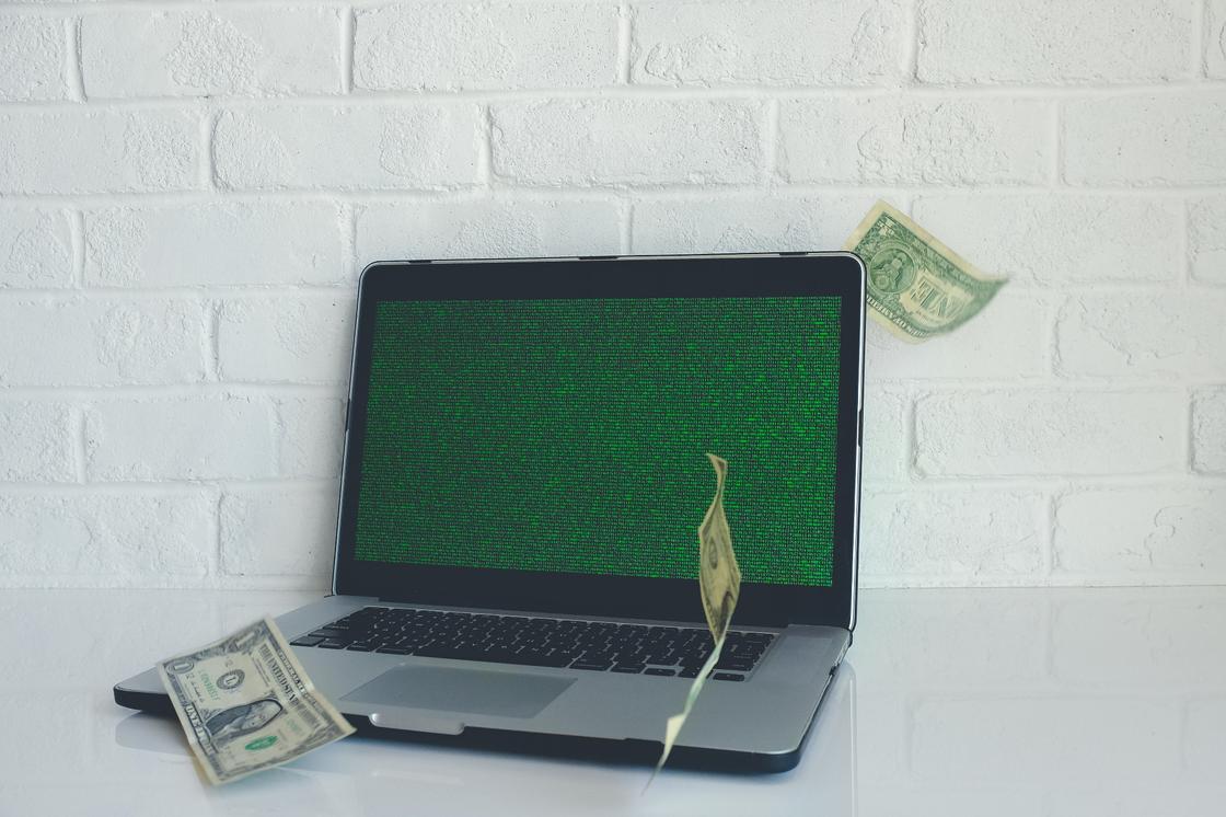 Вокруг ноутбука разбросаны доллары