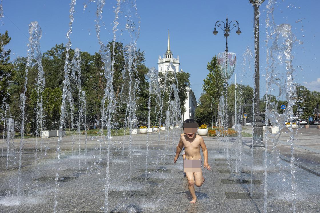 Ребенок бегает возле фонтана