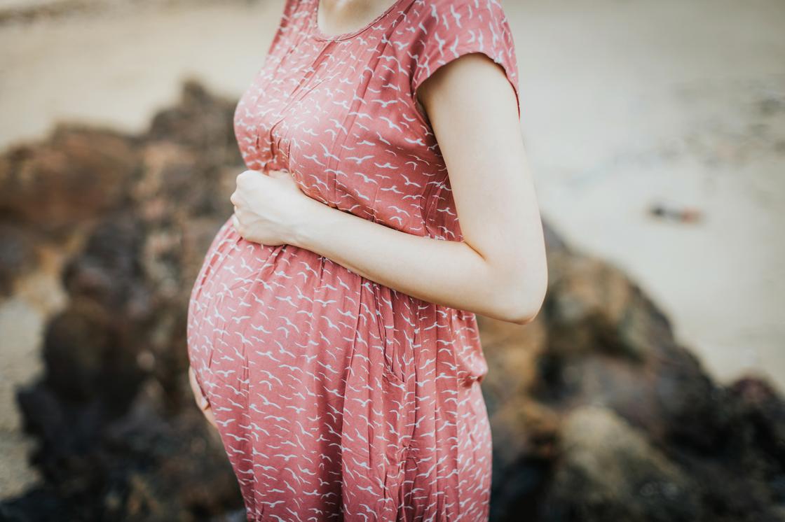 Беременная женщина стоит на улице