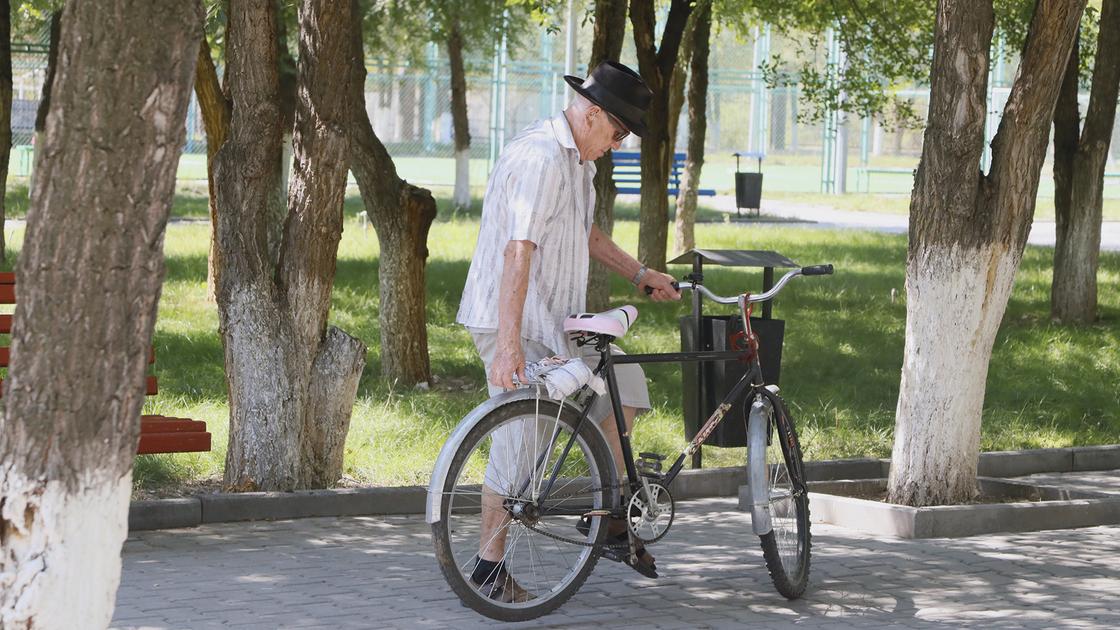 Мужчина с велосипедом стоит на дороге