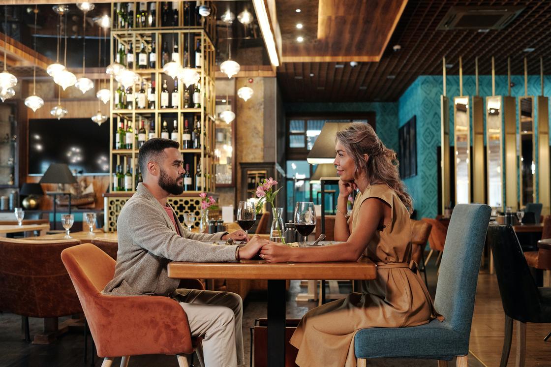 Мужчина и женщина сидят за столиком в ресторане