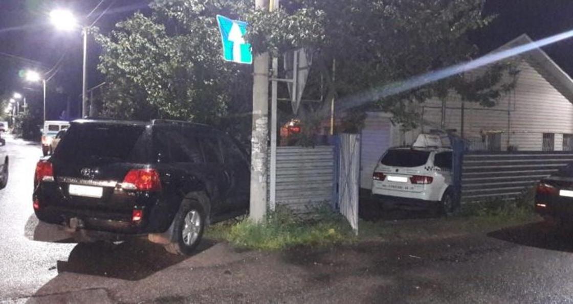 Снесли забор, врезались в дом: 3 человека пострадали в ДТП с участием такси и Land Cruiser в Алматы