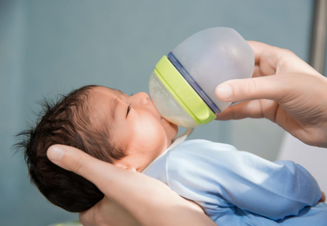 Младенца кормят с бутылочки