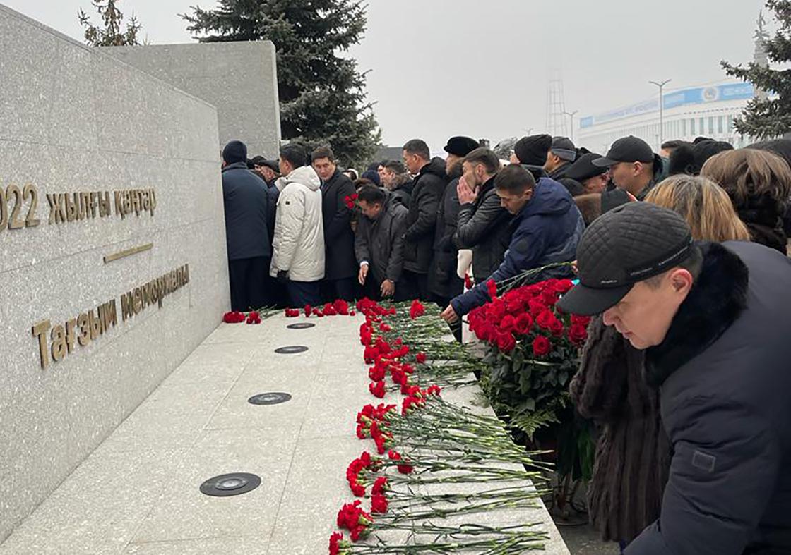 Люди кладут цветы на памятник