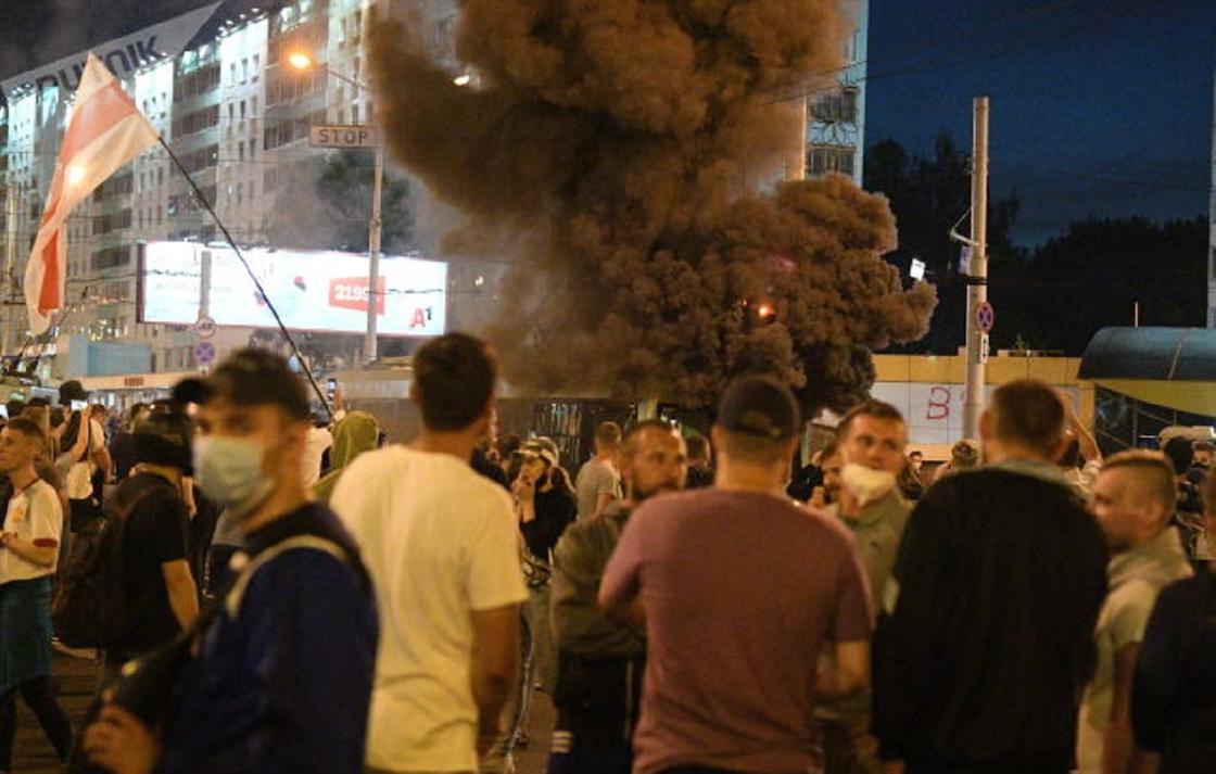Мужчины стоят на фоне черного дыма о взрыва