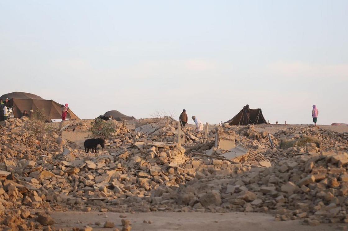 Ауғанстандағы жойқын жер сілкінісінің салдарынан қираған үйлер үйіндісінің үстінде жүрген адамдар