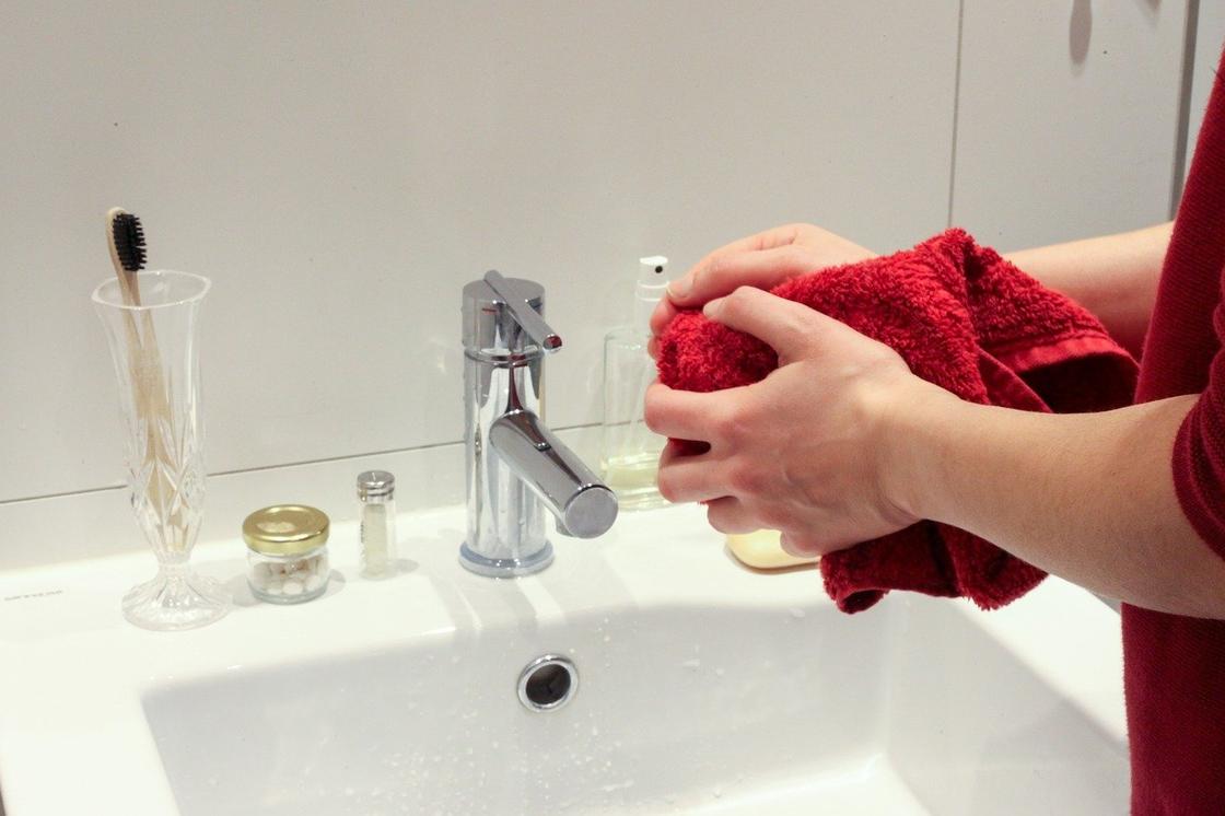 человек вытирает руки полотенцем