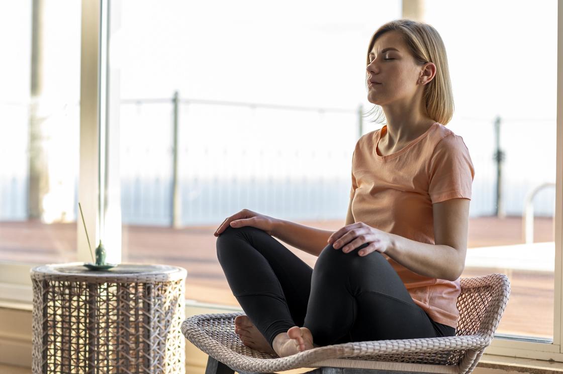 Женщина медитирует на террасе