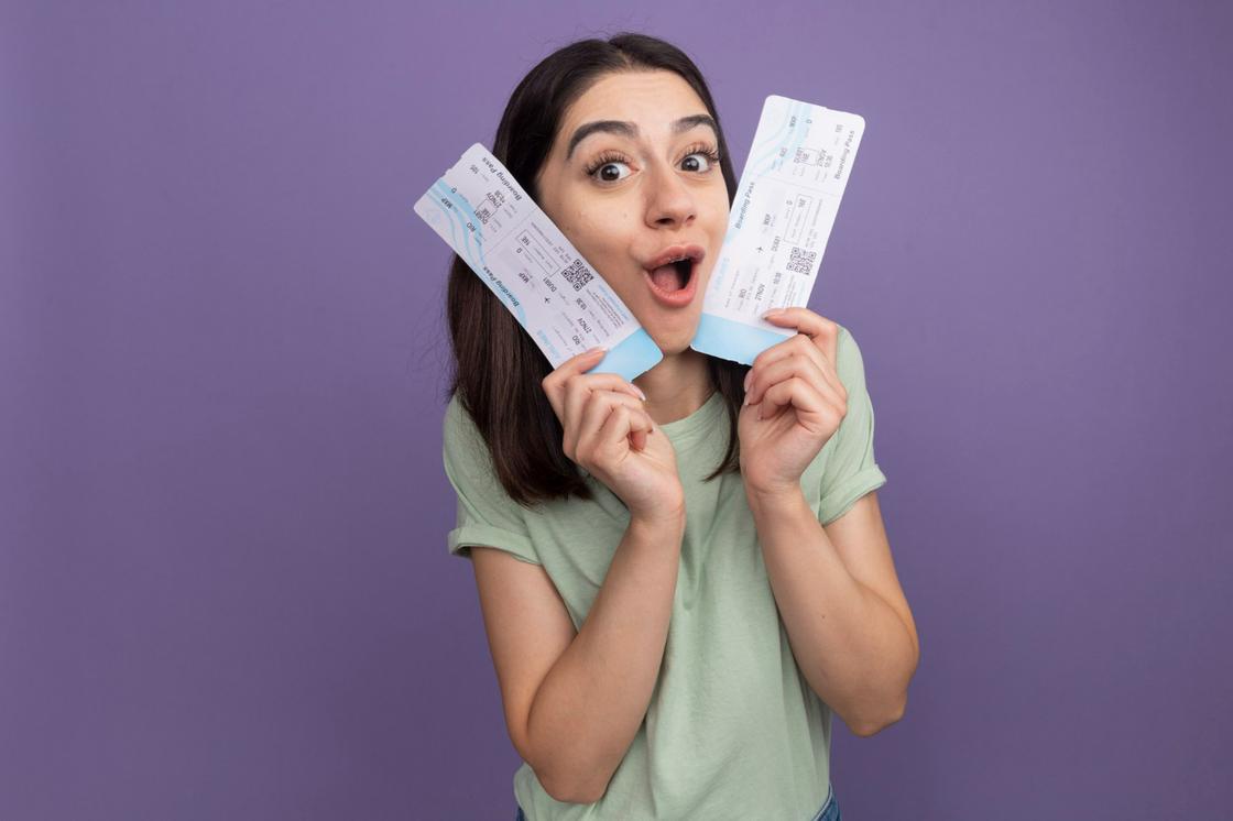 Девушка держит в руках два билета в кино