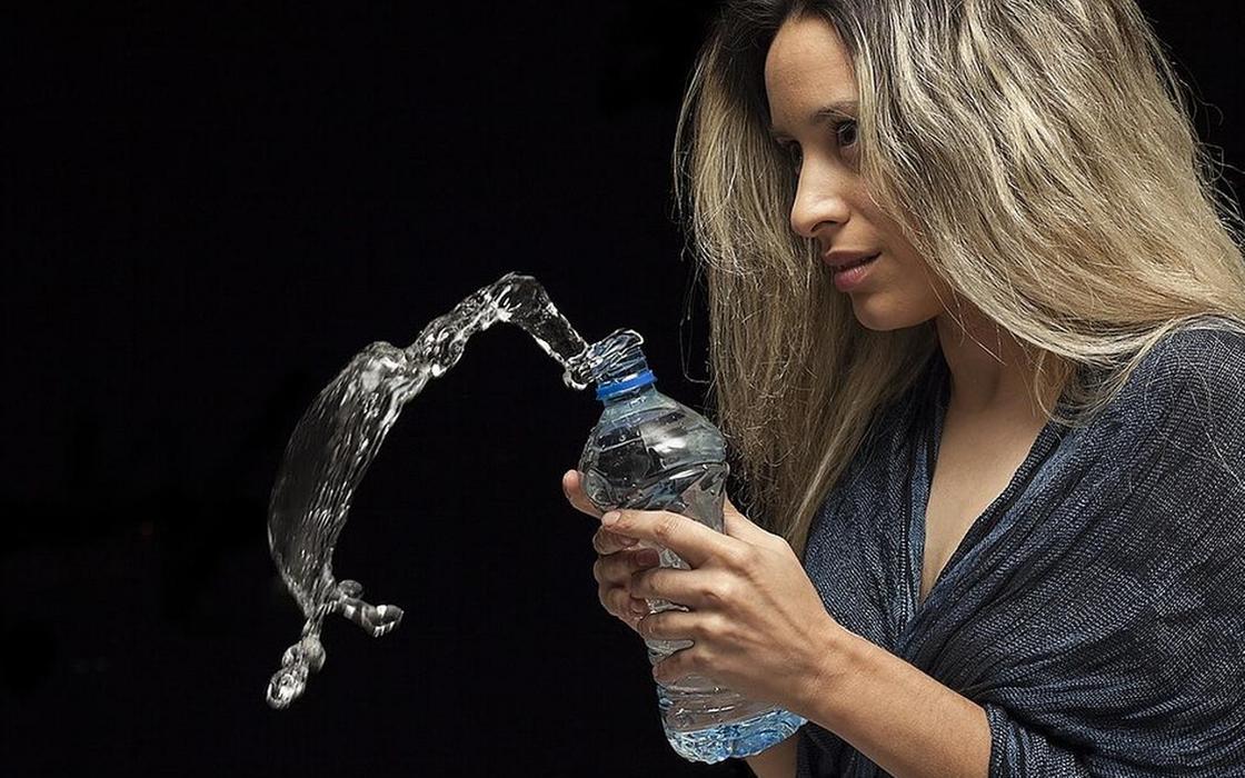Бутылка воды в руках у девушки Бутылка воды в руках у девушки