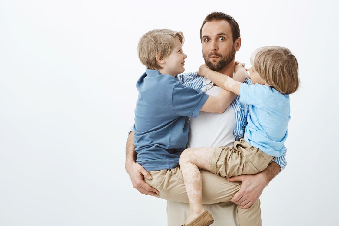 Мужчина с двумя детьми на руках