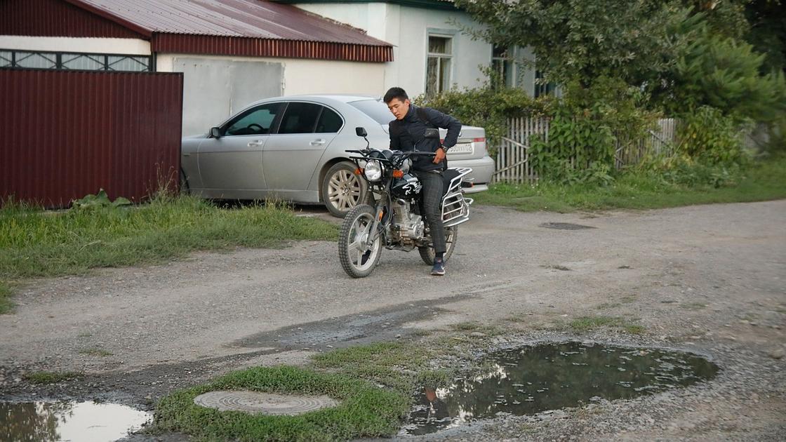 Парень стоит рядом с мотоциклом