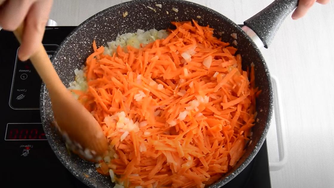 Тертая морковь и нарезанный лук в сковородке
