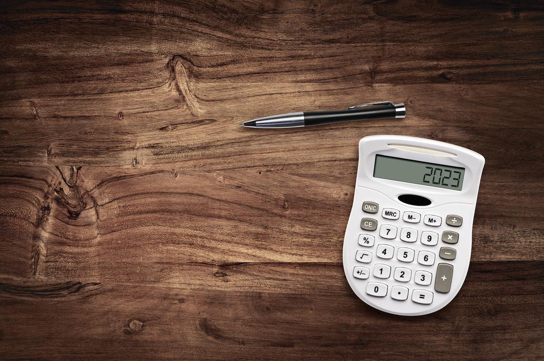 Калькулятор и ручка лежат на столе