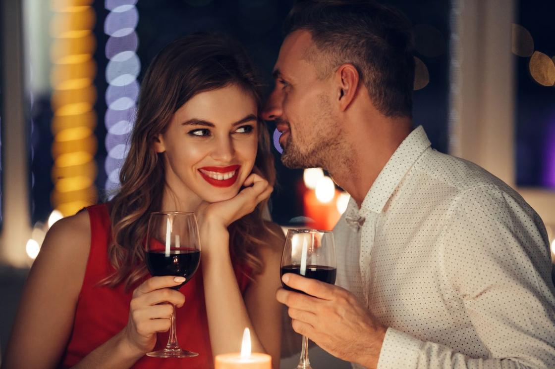 Пара секретничает за бокалом вина