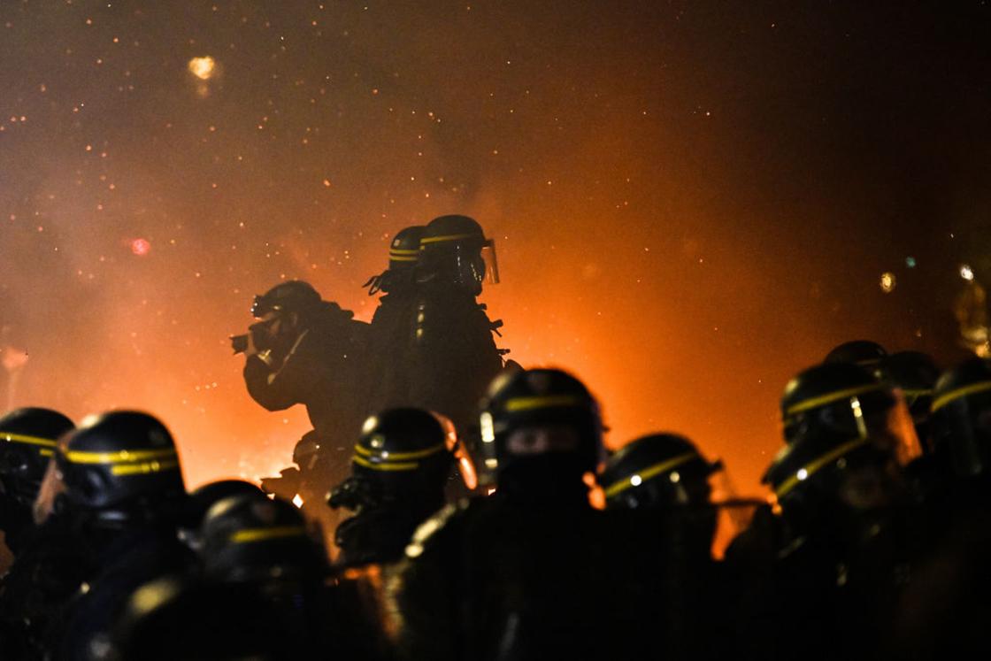 Полицейские стоят на фоне дымовой завесы