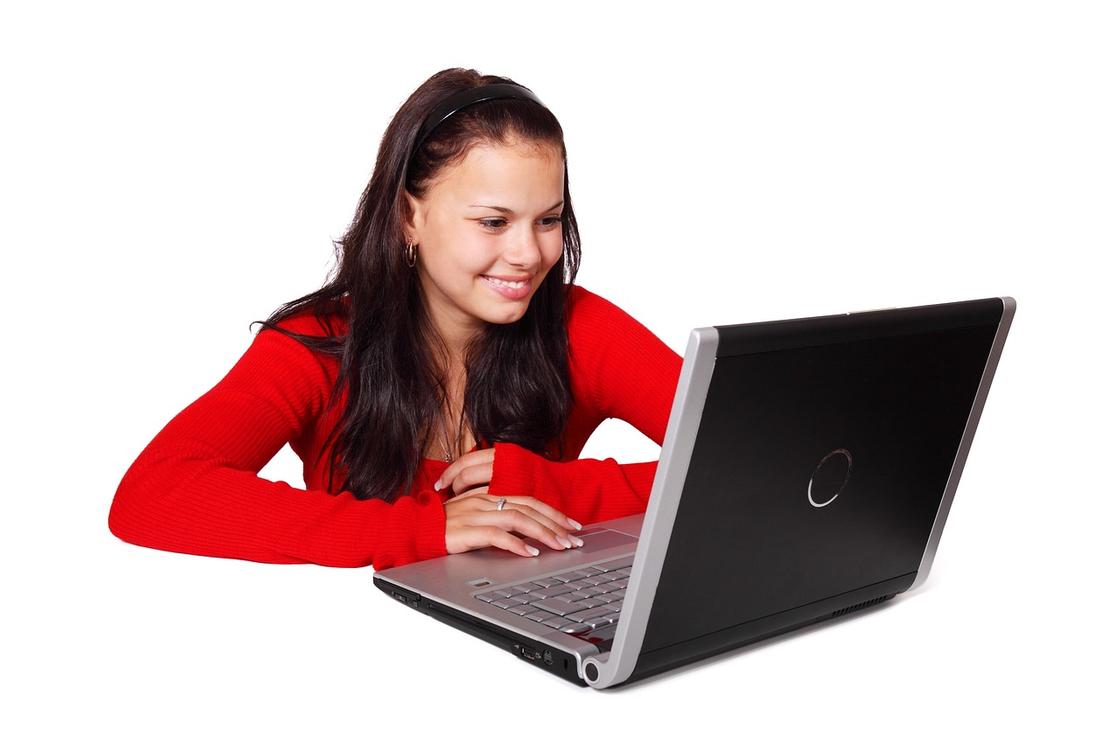 Девушка сидит за ноутбуком