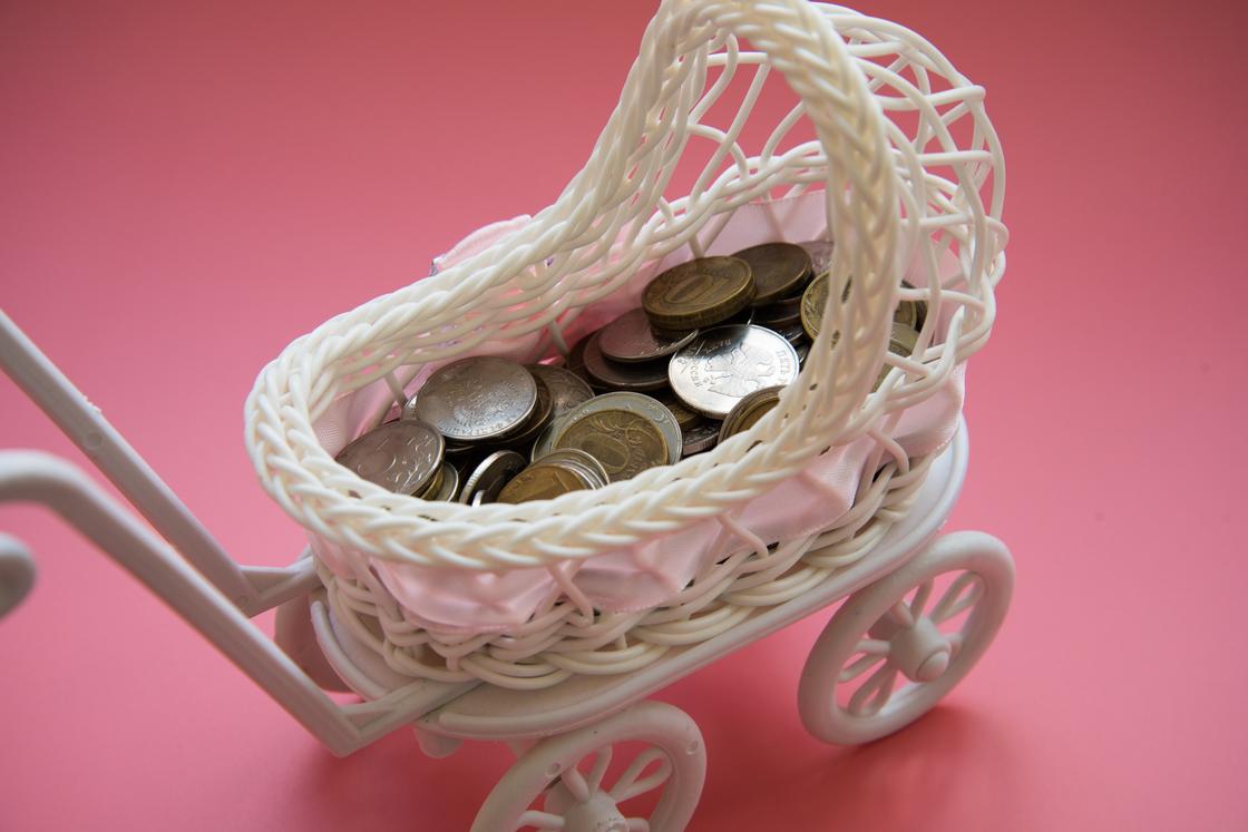 В игрушечной детской коляске лежат монеты