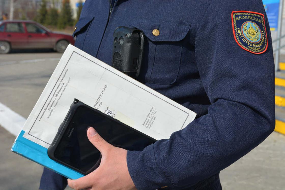 Полицейский держит в руке планшет и папку