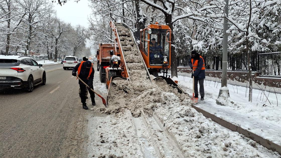 Коммуналдық қызмет мамандары қала көшесіндегі қарды шығарып жатыр Коммуналдық қызмет мамандары қала көшесіндегі қарды шығарып жатыр