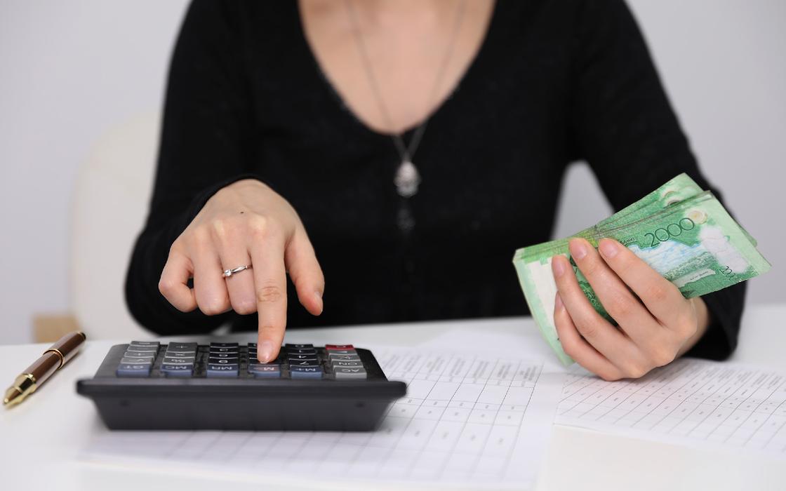 Женщина с калькулятором и деньгами