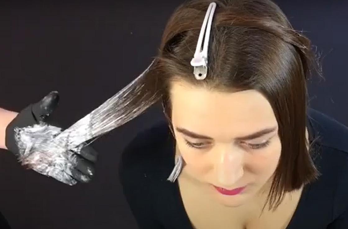Нанесение осветлителя на прядь волос