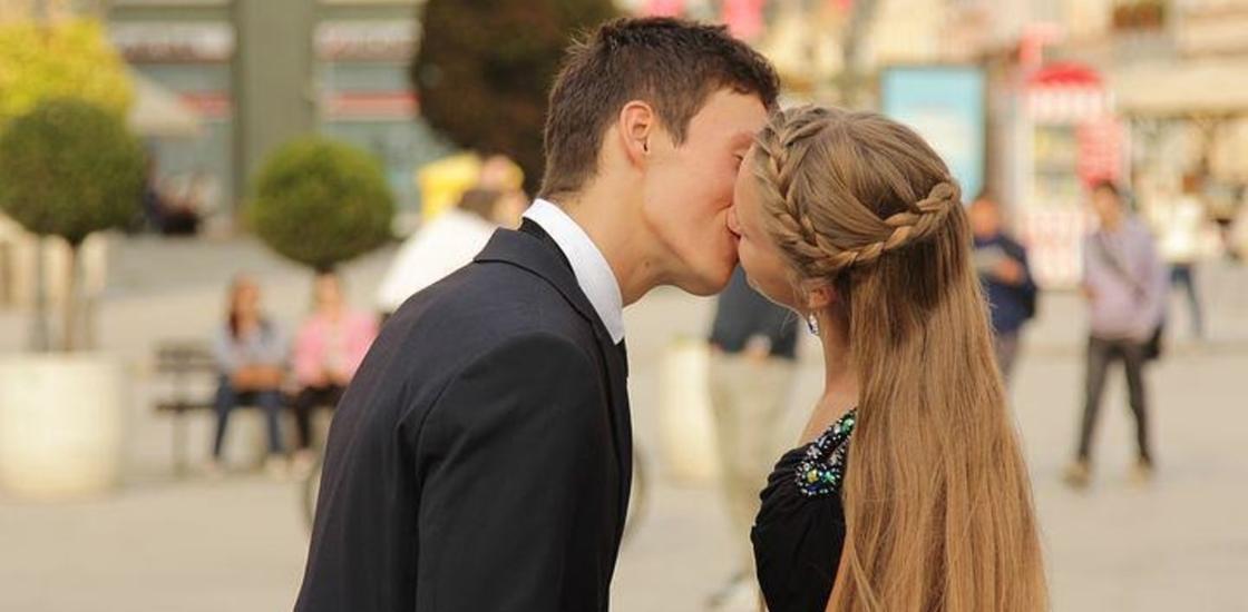 Парень с девушкой целуются на улице