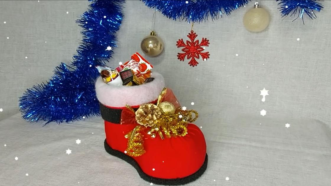 Рождественский сапог, наполненный сладостями, украшенный новогодним декором