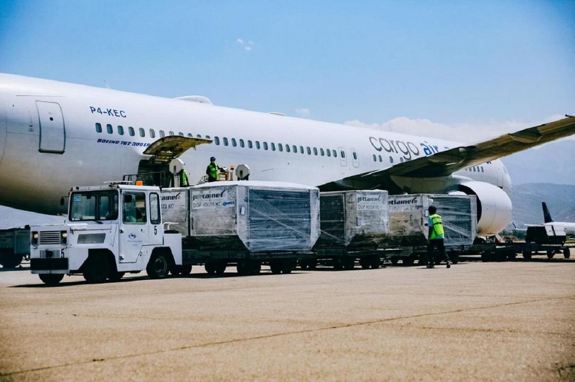 Работники выгружают из самолета вакцину