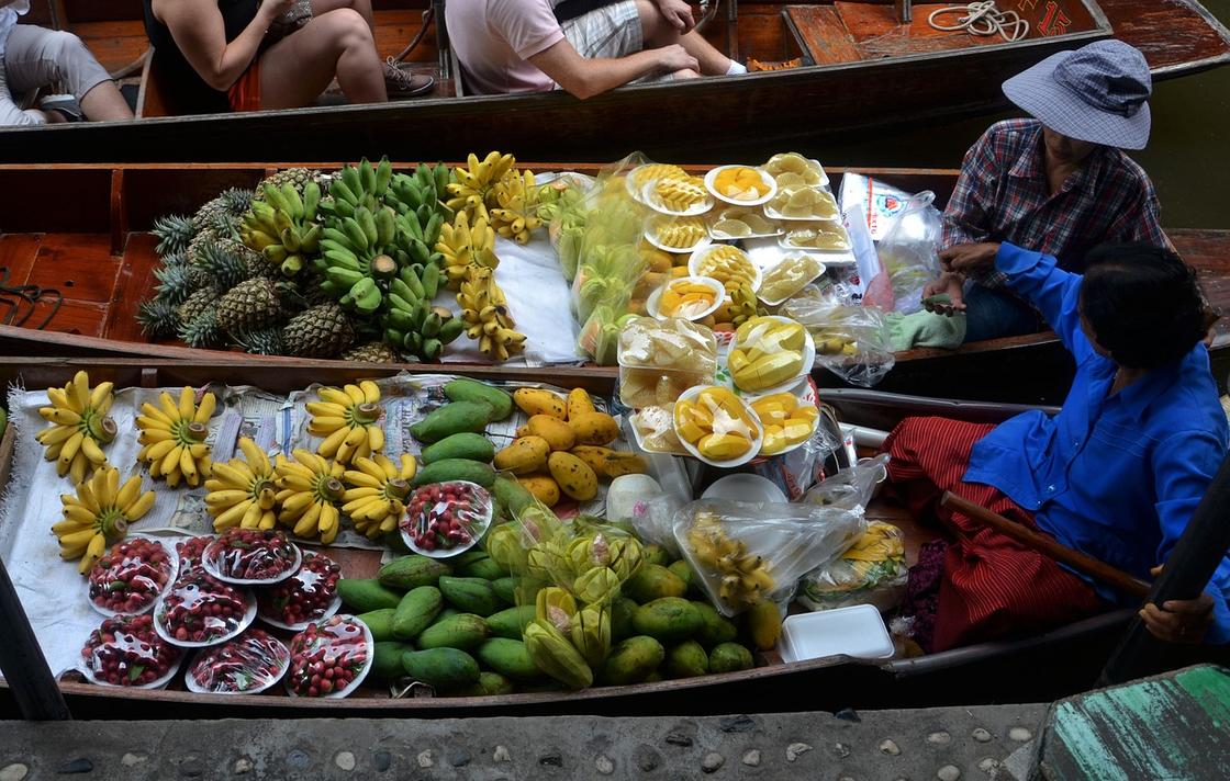 Торговцы перевозят в лодках бананы, ананасы, манго