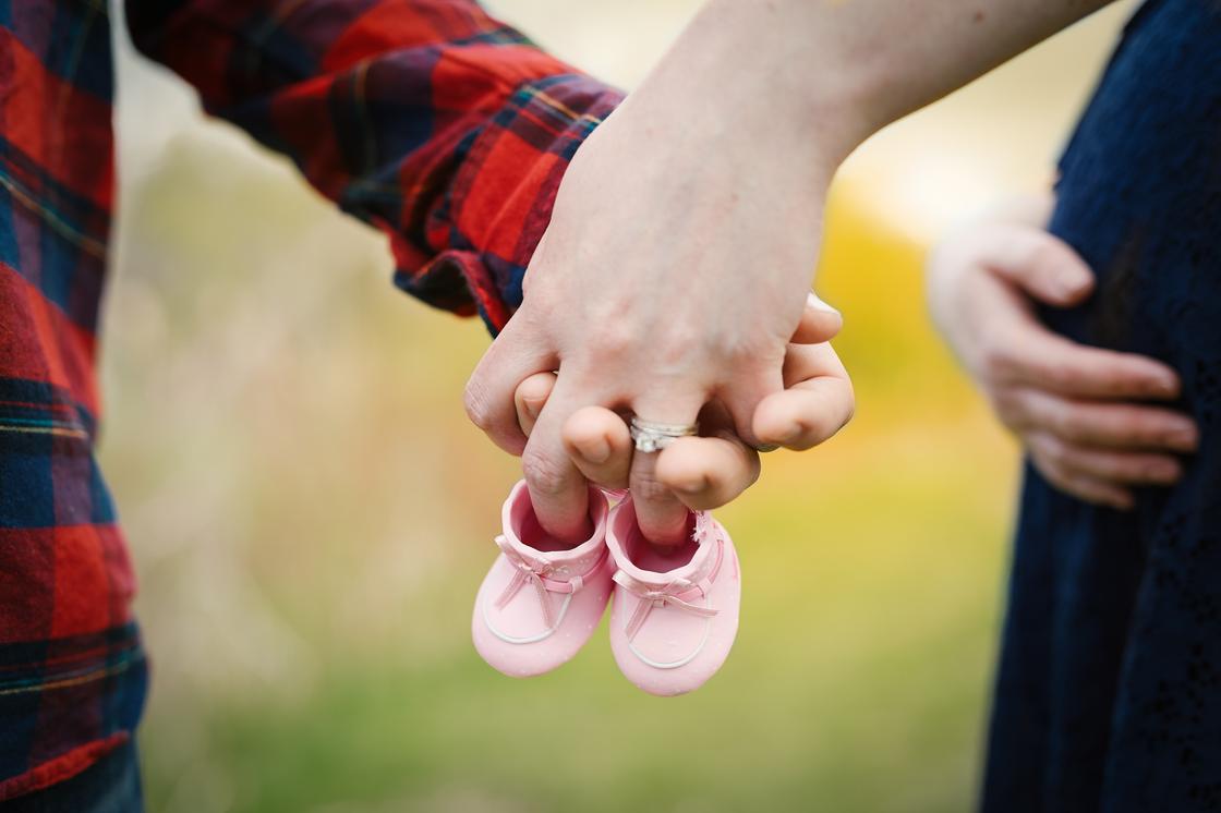 Детская обувь в руках мужчины и женщины
